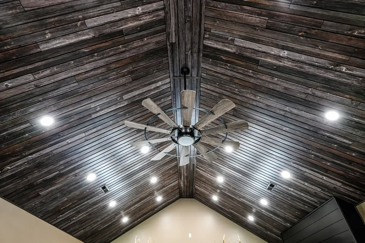 Vaulted barndominium ceiling finished in wood planks with recessed lights