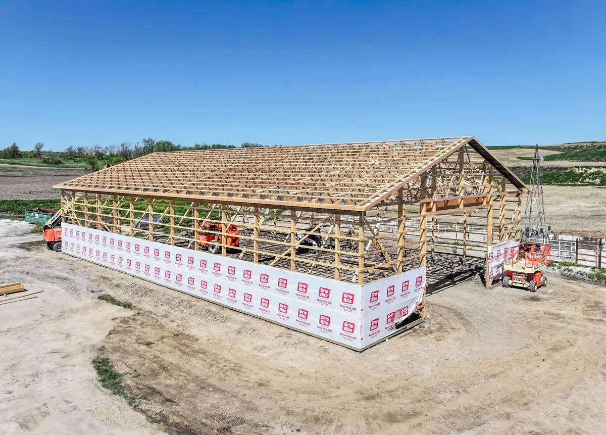 Post frame building skeleton with trusses set on a farm site