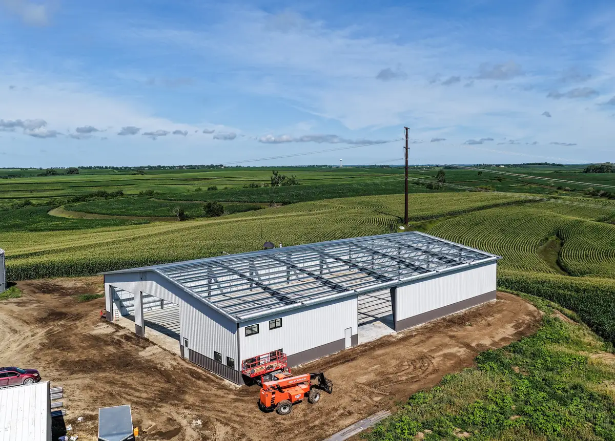 Drone view of a steel frame building going up in open country